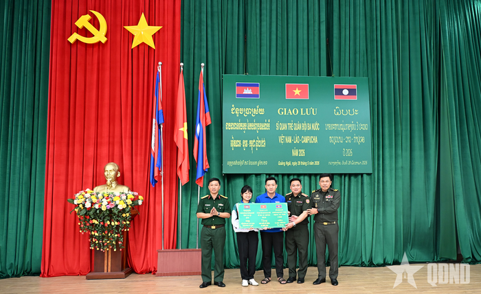 Đoàn sĩ quan trẻ ba nước trao bảng tượng trưng tặng vở học sinh cho trường học trên địa bàn xã Bờ Y. 