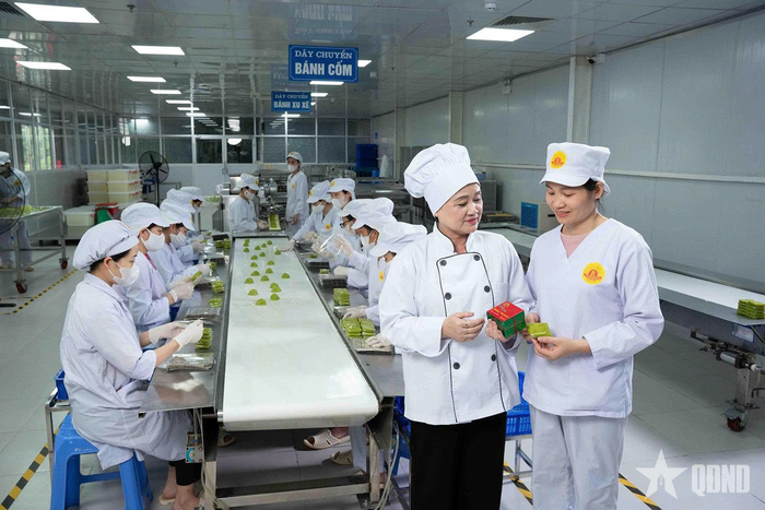Bà Ngô Thị Tính bên dây chuyền sản xuất bánh cốm. 