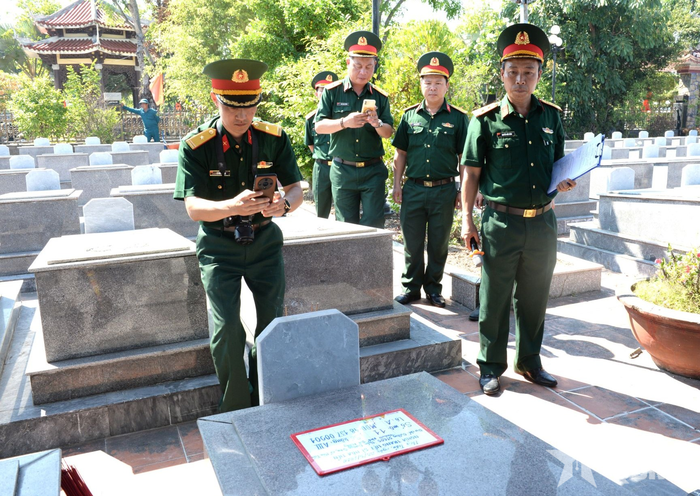  Cán bộ số hóa kiểm tra thông tin, chụp ảnh mộ cùng bảng thông tin có ghi mã định danh mẫu hài cốt liệt sĩ. 