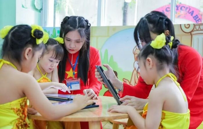 Học sinh Trường Mầm non Họa Mi theo dõi bài giảng sinh động qua máy tính bảng tại thư viện trường. Ảnh: Hà An.