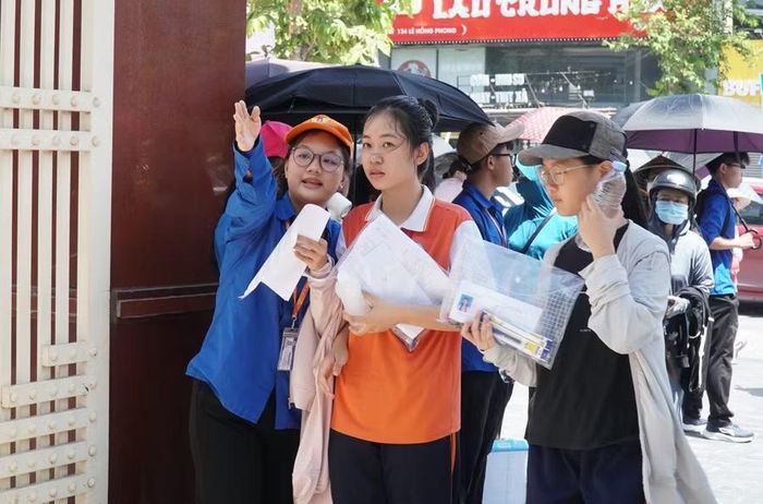 Đội thanh niên tình nguyện hướng dẫn thí sinh tìm phòng thi. Ảnh: Hồ Lài