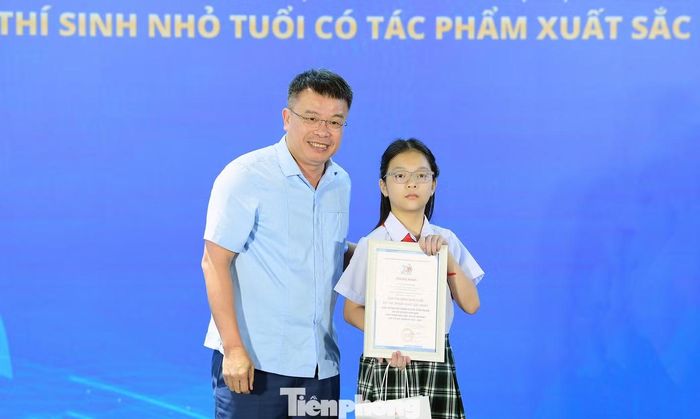 Nhà báo Nguyễn Phan Khuê -Tổng biên tập Báo Thiếu niên Tiền phong và Nhi đồng trao giải Thí sinh nhỏ tuổi có tác phẩm xuất sắc nhất. Ảnh: Xuân Tùng