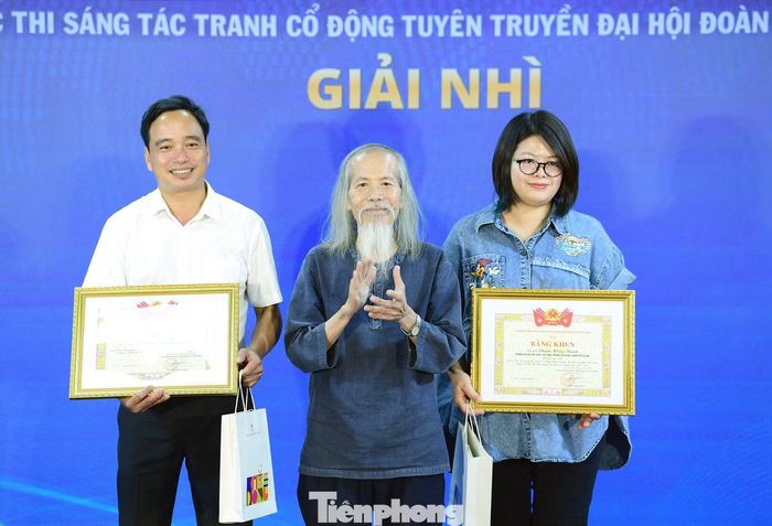 Họa sĩ Lương Xuân Đoàn trao giải Nhì cho các tác giả. Ảnh: Xuân Tùng