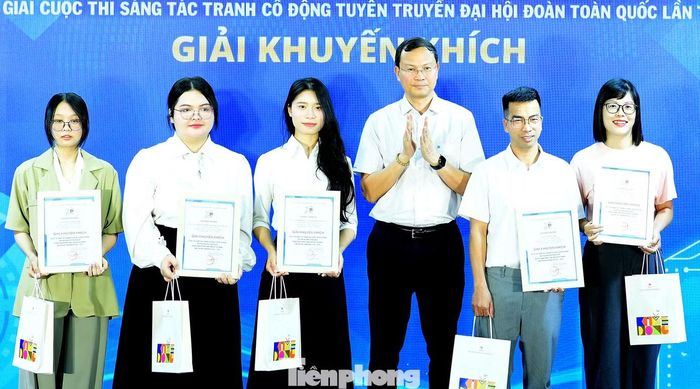 Ông Bùi Tuấn Nghĩa - Giám đốc Nhà xuất bản Kim Đồng trao giải Khuyến khích cho các tác giả. Ảnh: Xuân Tùng
