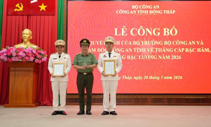 Thiếu tướng Lâm Phước Nguyên - Giám đốc Công an tỉnh Đồng Tháp trao quyết định cho các đồng chí được thăng cấp bậc hàm, nâng bậc lương năm 2026. Ảnh: Trọng Tín