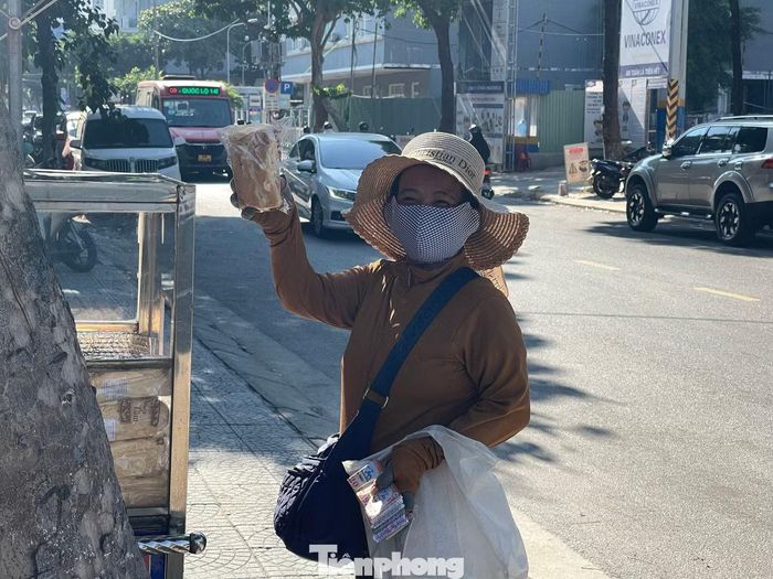 “Mỗi sáng ghé qua lấy một ổ bánh mì thấy vui lắm. Vừa tiện, vừa ấm lòng vì cảm giác được quan tâm như vậy”, bà Phan Thị Thanh (70 tuổi, phường Hải Châu, TP Đà Nẵng) chia sẻ. Khi nắng đã lên cao, những ổ bánh mì trong tủ cũng vơi dần sau từng lượt người ghé qua. Chiếc tủ nhỏ trên đường Quang Trung vẫn lặng lẽ đứng đó, như một điểm dừng quen thuộc, nơi những sẻ chia giản dị được trao đi mỗi sáng. Ảnh: Quỳnh Như - Yến Nhi