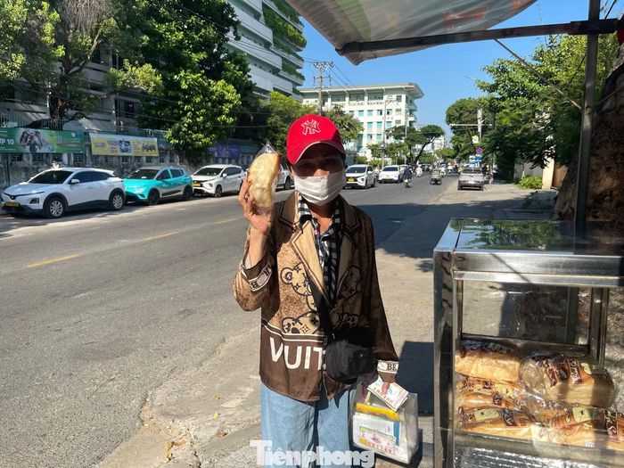 Trên chiếc tủ nhỏ có dòng chữ: “Bánh mì miễn phí dành cho người nghèo, mỗi người một ổ”. Quy định ấy được đặt ra để ai đến sau cũng còn phần, bởi có những người phải đi rất xa mới tới được, nếu lấy quá nhiều thì những người đến sau có thể không còn gì để nhận. “Tôi thấy quy định mỗi người một ổ ở đây rất hợp lý. Nhờ vậy ai đến cũng có phần, không bị thiếu, mà cũng thấy việc chia sẻ này rất ý nghĩa”, bà Nguyễn Thị Bê (70 tuổi, phường Hòa Xuân, TP Đà Nẵng) bày tỏ. Ảnh: Quỳnh Như - Yến Nhi