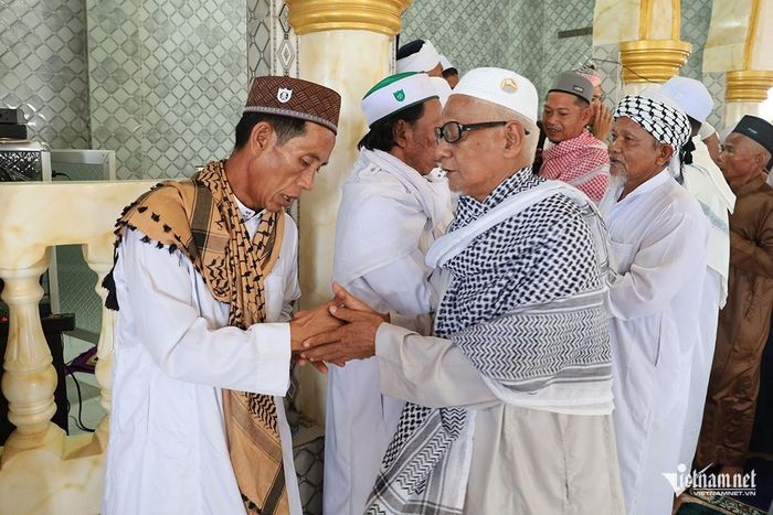 Ông Y Xa, dân tộc Chăm, ngụ ấp Bình Di, xã Khánh Bình, chia sẻ: “Sau khi hành lễ, mọi người sẽ đến thăm hỏi người thân, bà con lối xóm và thực hiện nghi thức xin tha thứ, xóa bỏ những hiềm khích trong cuộc sống. Đây là nét đẹp văn hóa giàu tính nhân văn của đồng bào Chăm An Giang được gìn giữ đến hôm nay”. Trong ảnh: Tại lễ cầu nguyện ở Thánh đường, đồng bào Chăm thực hiện nghi thức xin tha thứ, xóa bỏ những hiềm khích trong cuộc sống.