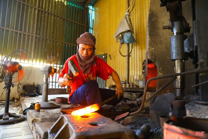 Bước chân vào các xưởng rèn, cảm giác oi nóng lập tức bao trùm. Tiếng búa chan chát vang lên liên hồi xen lẫn tiếng quạt phì phò và ánh lửa đỏ rực từ những thanh sắt nung nóng. Những người thợ chỉ mặc áo mỏng, mồ hôi nhễ nhại, tập trung cho từng công đoạn tạo hình sản phẩm.