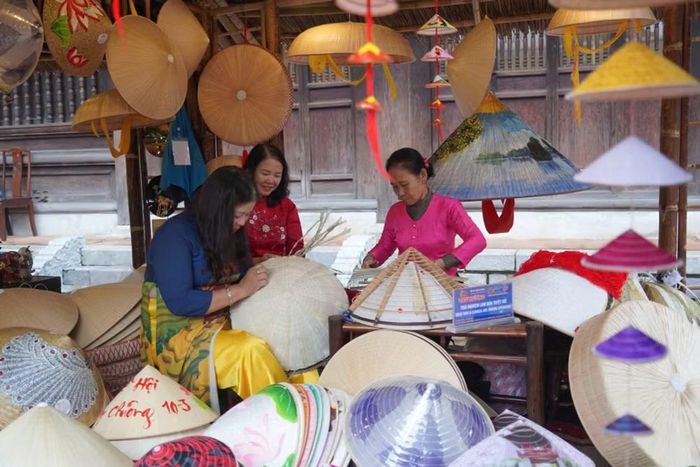 Du khách trải nghiệm làm nón tại một hoạt động được tổ chức ở Văn Miếu-Quốc Tử Giám. (Ảnh: CTV/Vietnam+)