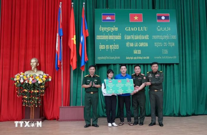 Đoàn sỹ quan trẻ ba nước tặng sách, vở cho học sinh tại xã Bờ Y, tỉnh Quảng Ngãi. (Ảnh: Dư Toán/TTXVN)