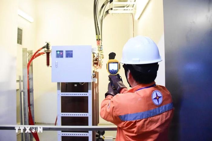 Công nhân EVNHANOI kiểm tra hệ thống điện thông qua thiết bị máy đo nhiệt hồng ngoại. (Ảnh: Quốc Lũy/TTXVN)