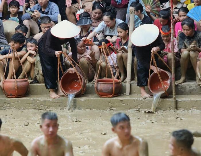 Tiếp thêm nước cho sân bùn. (Ảnh: Danh Lam /TTXVN)
