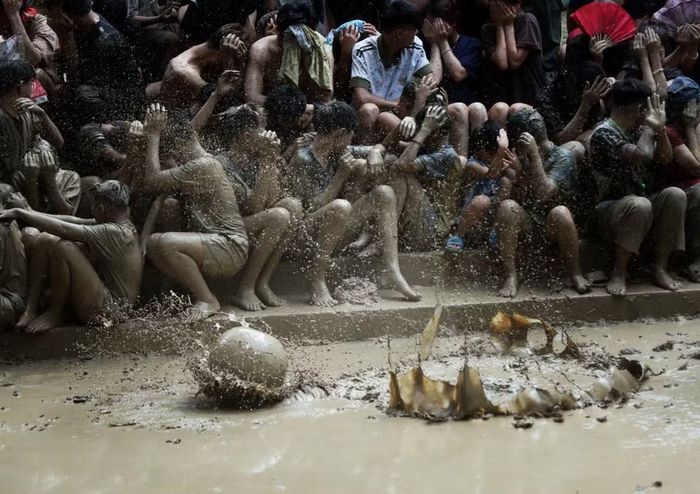 Người dân xem hội được “lộc bùn” bắn vào được coi là may mắn. (Ảnh: Danh Lam/TTXVN)