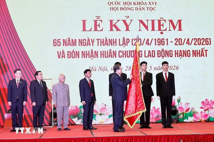 Chủ tịch Quốc hội Trần Thanh Mẫn gắn Huân chương Lao động hạng Nhất của Chủ tịch nước lên lá cờ truyền thống của Hội đồng Dân tộc của Quốc hội. (Ảnh: Doãn Tấn/TTXVN)