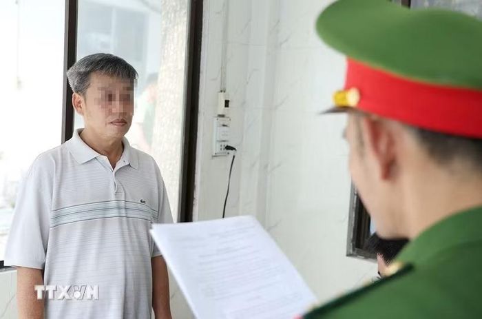 Cơ quan Công an tống đạt các quyết định và lệnh đối với bị can Nguyễn Huy Đạt. (Ảnh: TTXVN phát)