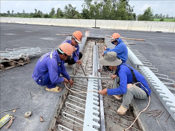 Công nhân khẩn trương lắp đặt khe co giãn cầu Đông 2 (xã Vĩnh Hanh, tỉnh An Giang), bảo đảm an toàn và khả năng khai thác lâu dài của cầu. Ảnh: Thanh Sang/TTXVN