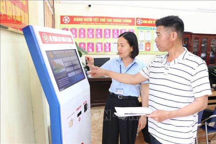 Công chức Trung tâm Phục vụ hành chính công xã Kim Thành hướng dẫn người dân làm thủ tục hành chính.