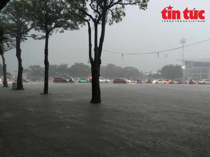 Tuyến đường phía trước Sân vận động Mỹ Đình bị ngập sâu, người dân gặp nhiều khó khăn khi di chuyển.