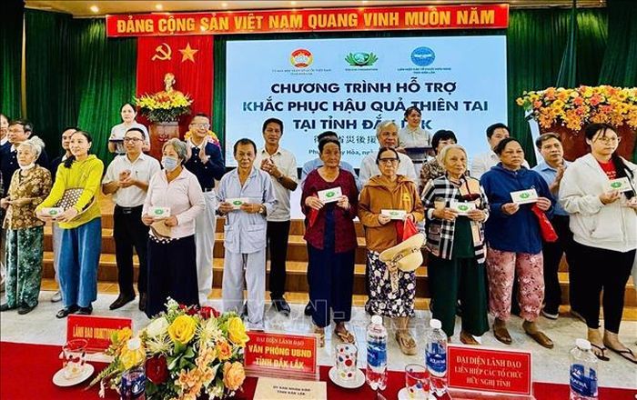 Trao tiền, quà hỗ trợ người dân vùng lũ. Ảnh: CTV/TTXVN