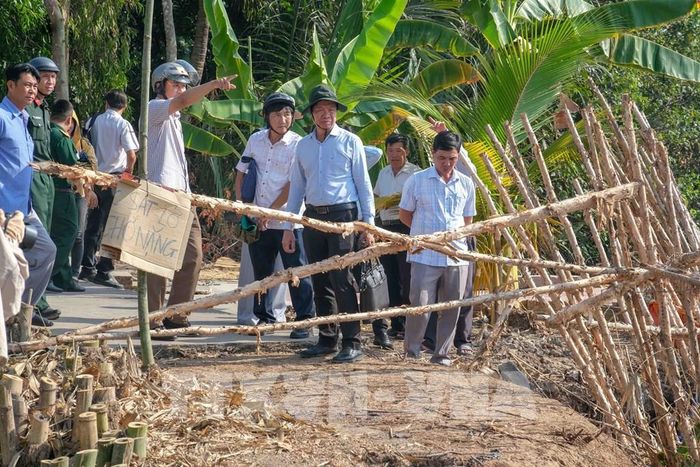 Lãnh đạo Sở Nông nghiệp và Môi trường thành phố Cần Thơ cùng chính quyền xã Nhơn Mỹ khảo sát một điểm sạt lở bờ sông Rạch Mọp. Ảnh: Thanh Liêm - TTXVN