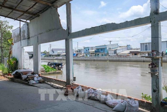 Một căn nhà ven kênh Xáng Nàng Mau (xã Thạnh Hòa, thành phố Cần Thơ) bị sạt lở chỉ còn lại những cây cột nằm sát mé sông. Ảnh: Thanh Liêm - TTXVN