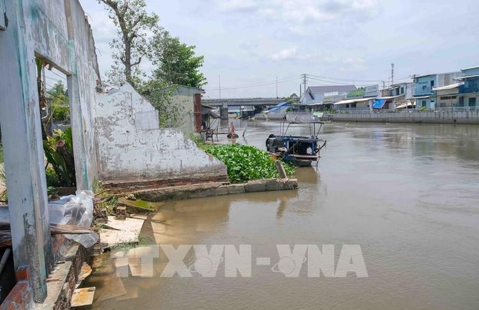 Vị trí sạt lở trên kênh Xáng Nàng Mau (xã Thạnh Hòa, thành phố Cần Thơ) khiến dãy nhà ven sông bị nhấn chìm. Ảnh: Thanh Liêm - TTXVN