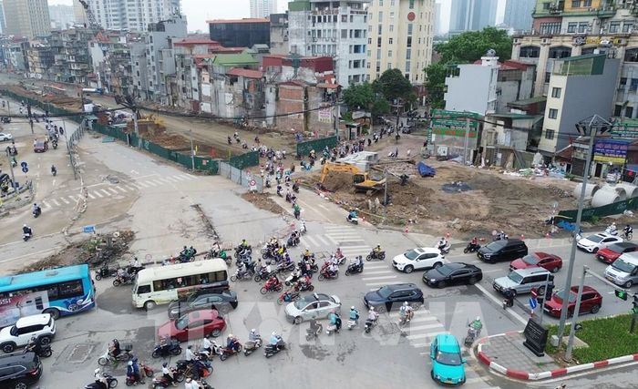 Hhướng từ Nguyễn Chí Thanh đi Nguyên Hồng, xe máy và phương tiện thô sơ sẽ di chuyển theo hệ thống biển chỉ dẫn vào tuyến đường tạm được bố trí sát khu vực rào chắn. Tuyến đường này có mặt cắt rộng khoảng 7m, được thi công bằng kết cấu bê-tông nhằm bảo đảm an toàn cho người tham gia giao thông. Ảnh: Quốc Khánh - TTXVN