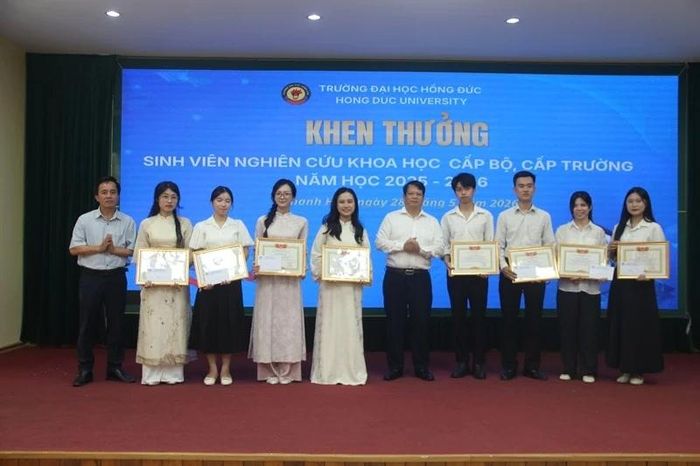 Đại diện lãnh đạo Trường Đại học Hồng Đức và Hội Khuyến học nhà trường khen thưởng 8 đề tài NCKH đoạt giải nhất cấp trường.
