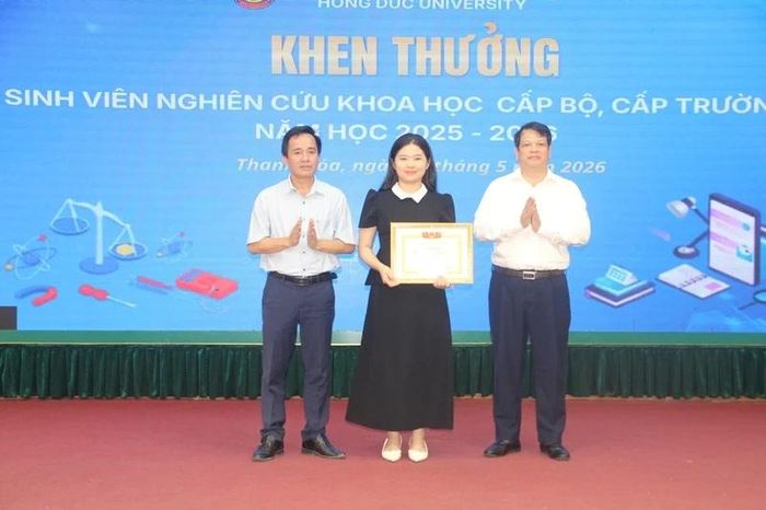 Đại diện lãnh đạo Trường Đại học Hồng Đức và Hội Khuyến học nhà trường khen thưởng cho nhóm sinh viên có đề tài NCKH đoạt giải nhì cấp bộ.