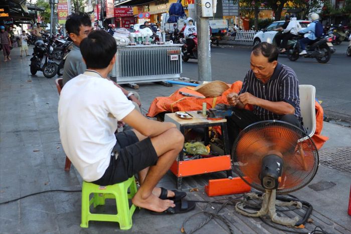 Người thợ sửa khóa phải dùng đến quạt điện công suất lớn nhưng vẫn không ngăn được mồ hôi nhễ nhại.