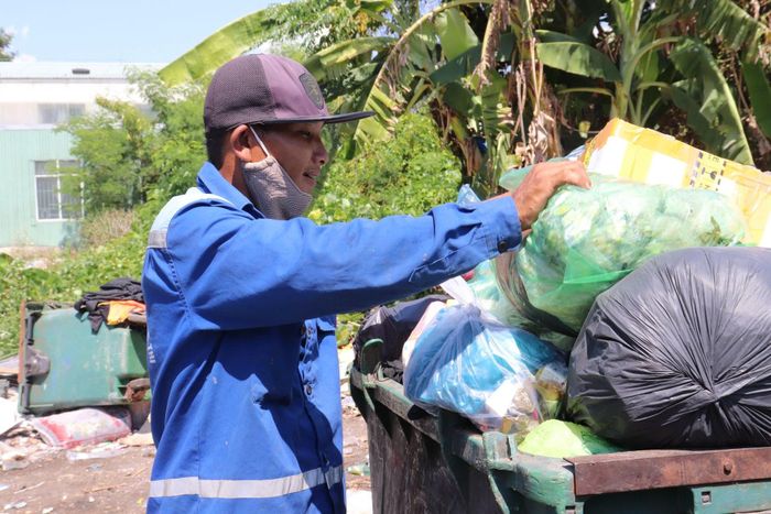 Người lao công “đội nắng” dọn rác, mồ hôi thấm đẫm từng tấm áo.