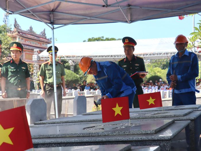 Tổ chức lấy mẫu với phần mộ liệt sĩ chưa xác định thông tin tại Nghĩa trang liệt sĩ xã Hòa Tiến. Ảnh: QUỐC TUẤN