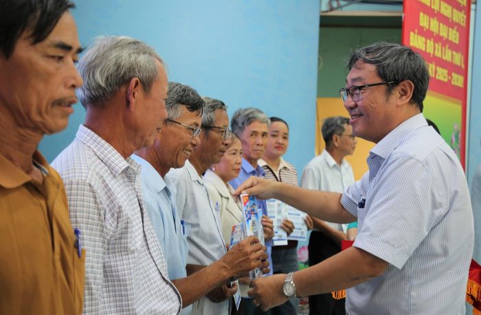 Bí thư Đảng ủy xã Tam Xuân Lê Văn Sinh trao cẩm nang số cho các bí thư chi bộ. Ảnh: ALĂNG NGƯỚC