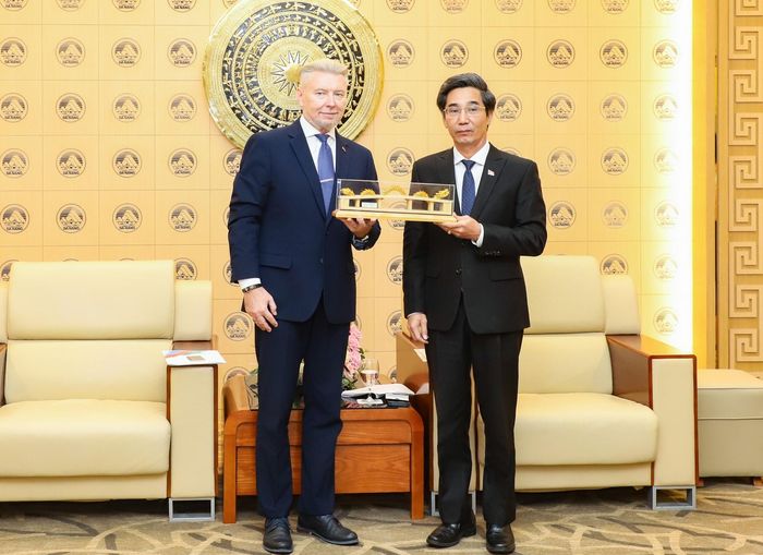 Phó Chủ tịch UBND thành phố Trần Chí Cường (bên phải) tặng quà lưu niệm cho Tổng Lãnh sự quán Belarus. Ảnh: NGỌC PHÚ