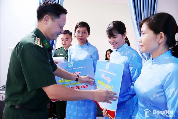 Đại tá Phạm Văn Đảng, Ủy viên Thường vụ Đảng ủy Quân sự, Phó Chính ủy Bộ Chỉ huy Quân sự thành phố kiêm Chính ủy Ban chỉ huy Bộ đội biên phòng Đồng Nai trao tặng kinh phí thực hiện mô hình tại các xã biên giới. Ảnh: Nguyệt Hà