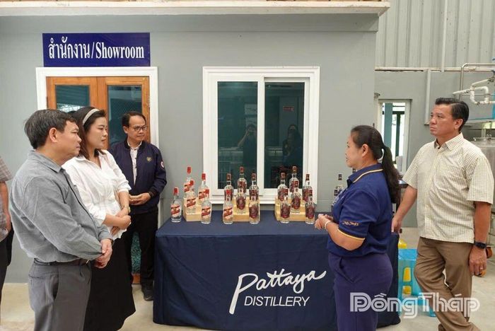 Giám đốc doanh nghiệp giới thiệu với Đoàn công tác về sản phẩm rượu làm từ cây mía. 