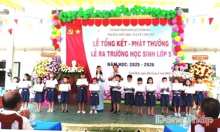 Đồng chí Tạ Minh Tâm cùng lãnh đạo nhà trường trao Giấy khen cho các em học sinh.