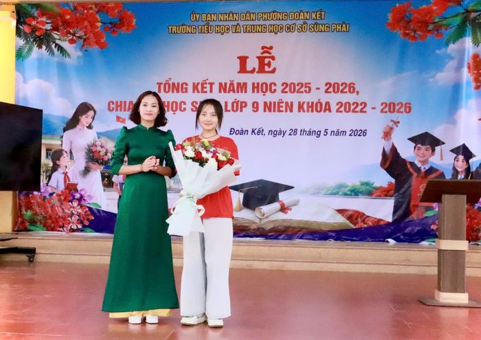 Cô giáo Trần Lệ Quyên - Bí thư Chi bộ, Hiệu trưởng Trường Tiểu học và THCS Sùng Phài tặng hoa cho đại diện học sinh lớp 9.