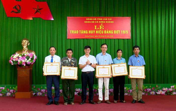 Lãnh đạo Đảng ủy, UBND xã Hưng Khánh trao Huy hiệu Đảng cho các đảng viên.