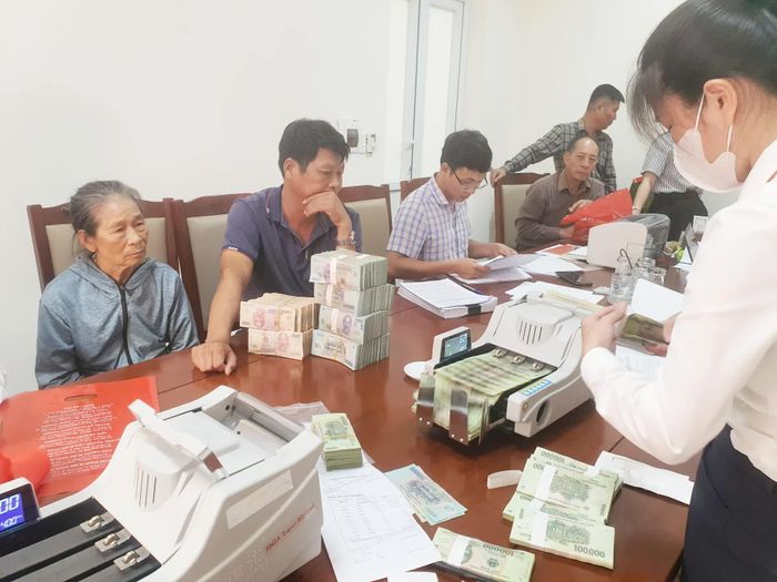 Các hộ dân nhận chi trả tiền bồi thường, hỗ trợ, tái định cư - Ảnh: B.T
