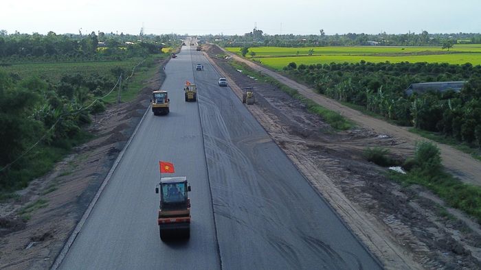 Theo ghi nhận của PV Báo Xây dựng sáng 28/5, dọc tuyến hàng chục xe lu, xe cơ giới, vận chuyển vật liệu tấp nập ra vào công trường triển khai nhiều mũi thảm nhựa mặt đường, dỡ tải... làm đường gom dân sinh.