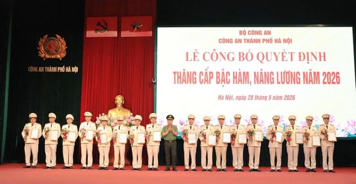 Trung tướng Nguyễn Thanh Tùng, Giám đốc CATP trao quyết định, tặng hoa chúc mừng các đồng chí được thăng cấp bậc hàm, nâng lương cấp bậc