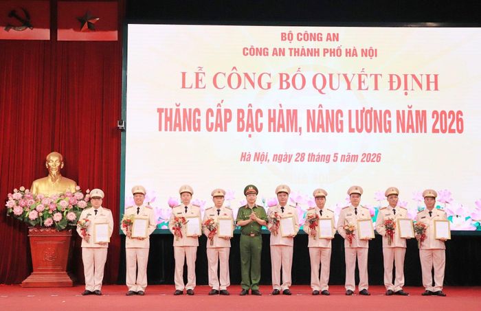 Thiếu tướng Nguyễn Hồng Ky, Phó Giám đốc CATP trao quyết định, tặng hoa chúc mừng các đồng chí được thăng cấp bậc hàm