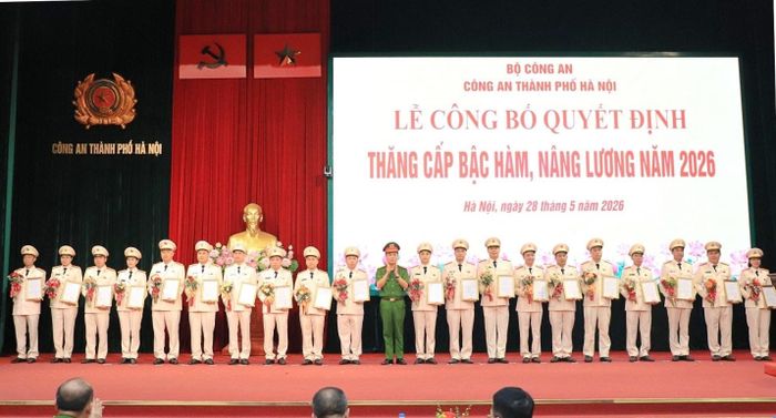 Đại tá Lê Văn Tuân, Phó Giám đốc CATP trao quyết định, tặng hoa chúc mừng các đồng chí được thăng cấp bậc hàm
