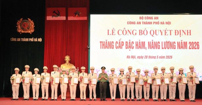Đại tá Nguyễn Ngọc Quyền, Phó Giám đốc CATP trao quyết định, tặng hoa chúc mừng các đồng chí được thăng cấp bậc hàm