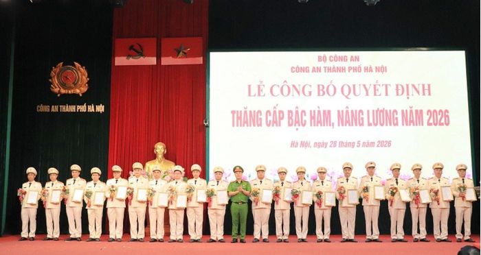 Đại tá Nguyễn Đức Long, Phó Giám đốc CATP trao quyết định, tặng hoa chúc mừng các đồng chí được thăng cấp bậc hàm