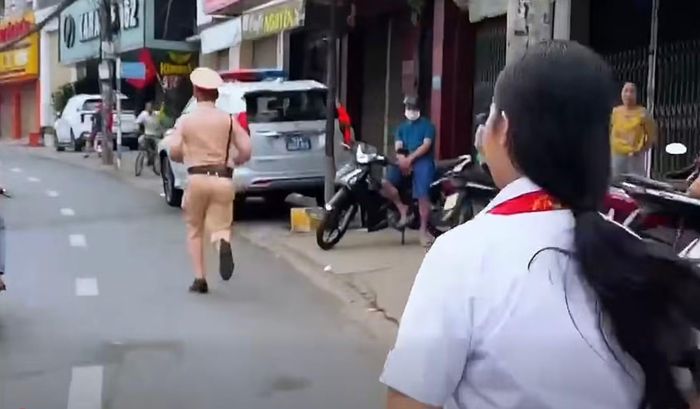 CSGT nhanh chóng chạy đến lấy xe ô tô chở thí sinh đến điểm thi. Ảnh cắt từ clip.