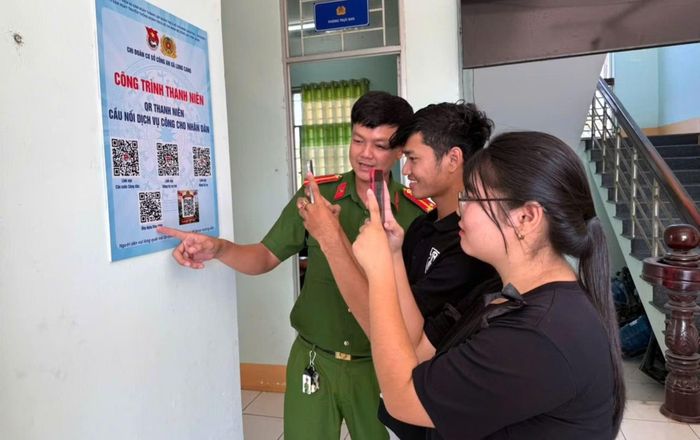 Công an xã Long Cang tận tình hướng dẫn người dân quét mã QR tích hợp các thủ tục hành chính.