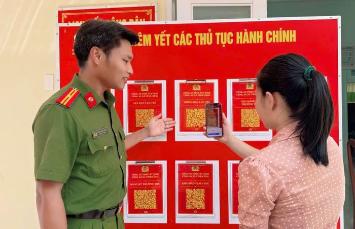 Công an xã Vĩnh Công hướng dẫn người dân quét các mã QR giải quyết các thủ tục hành chính.